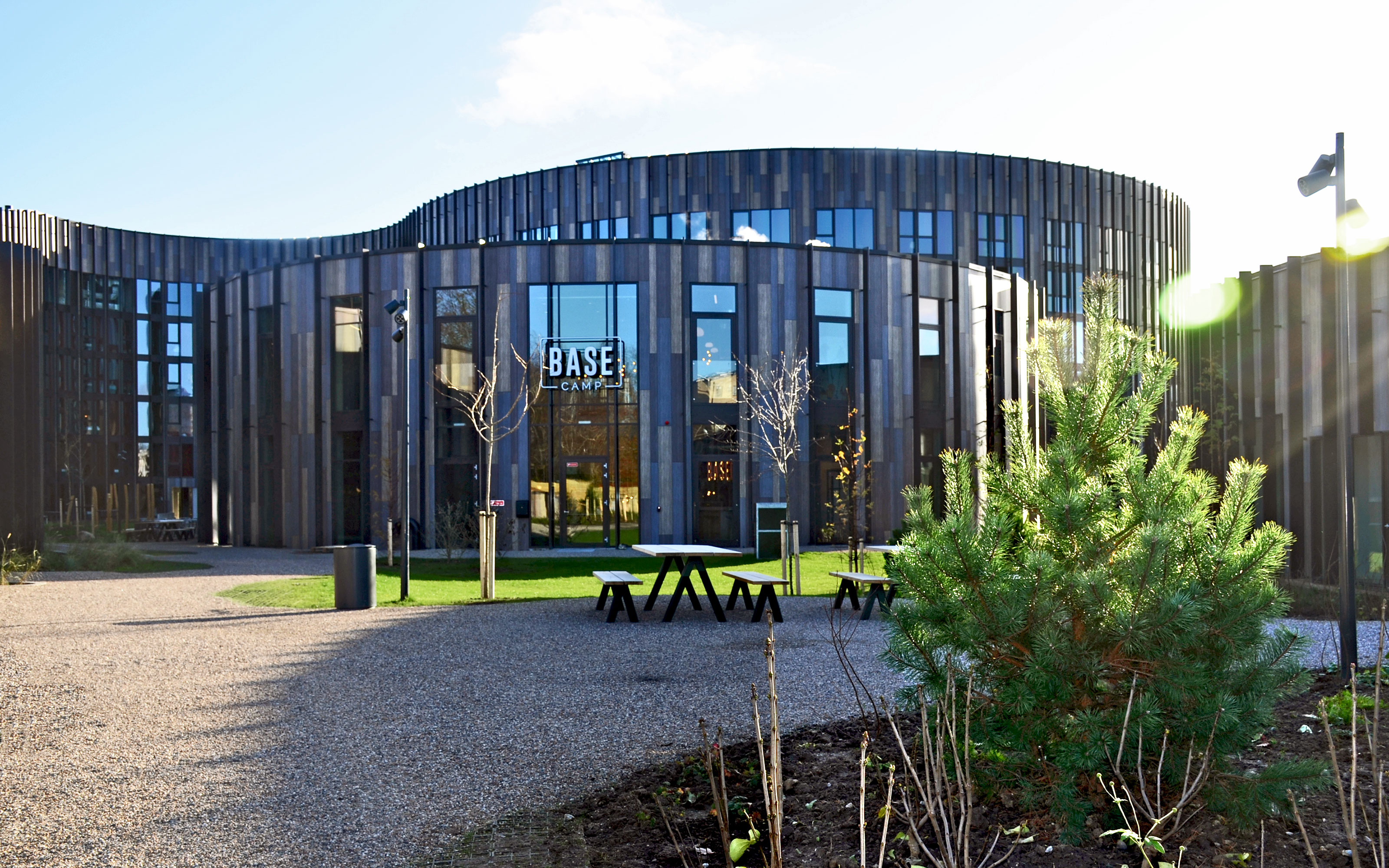 Courtyard with greenery, gravel pathways, wooden benches and tables